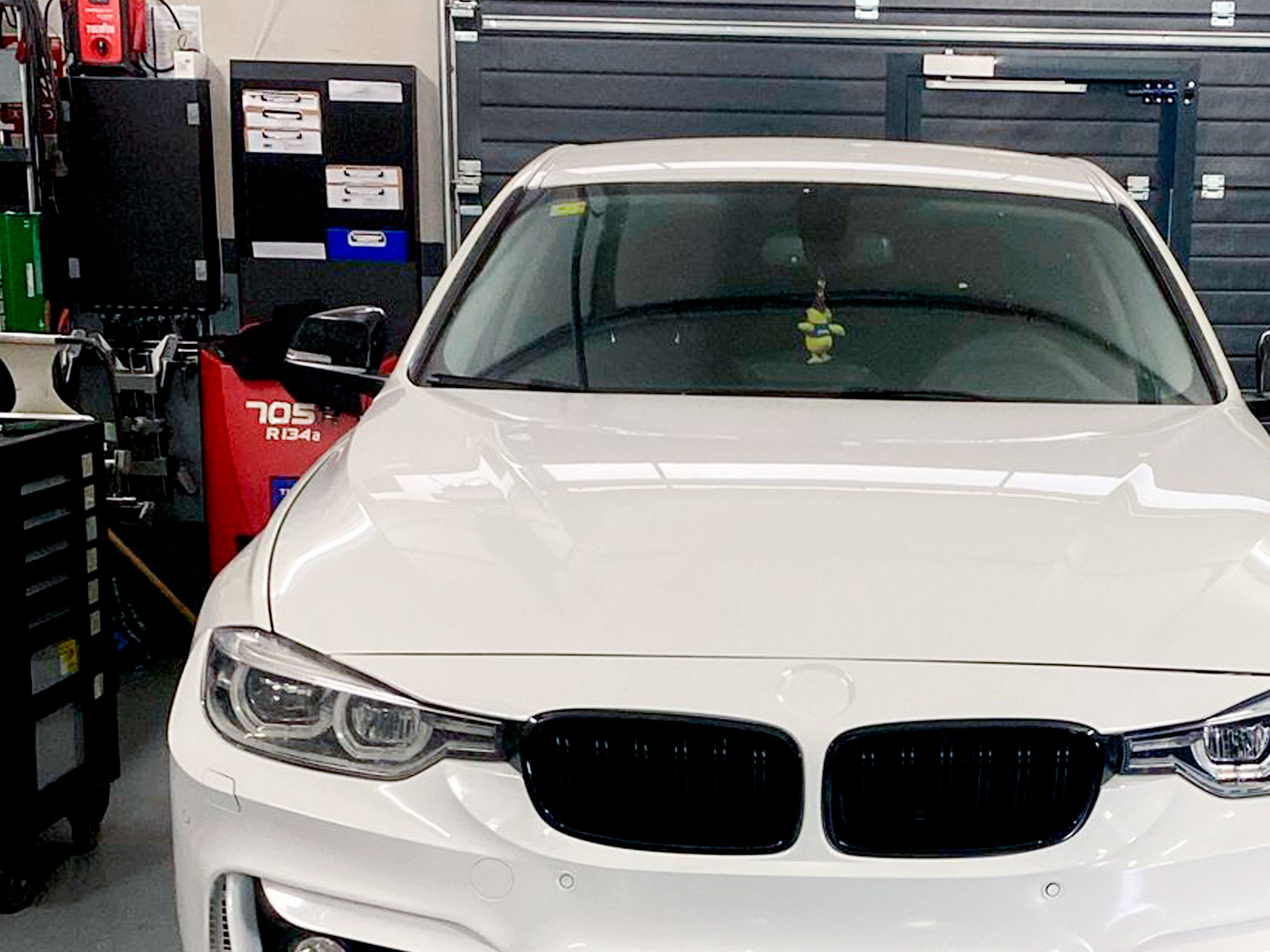 Automóvil blanco en una zona del taller mecánico